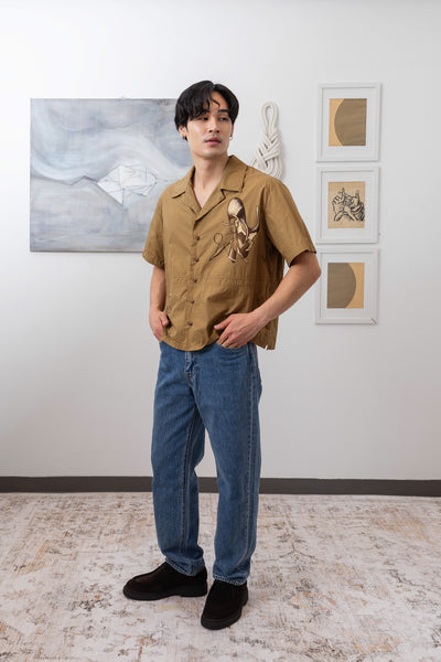 Three quarter view of tan bowling hand painted shirt in italian cotton by nowhere studio