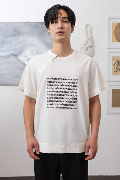 Close-up front of white menswear shirt showing invisible zipper neckline and logo embroidered graphic by nowhere studio