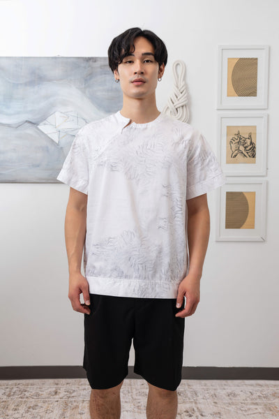 Close-up front of white printed menswear shirt showing invisible zipper neckline and trompe l'oeil print by nowhere studio