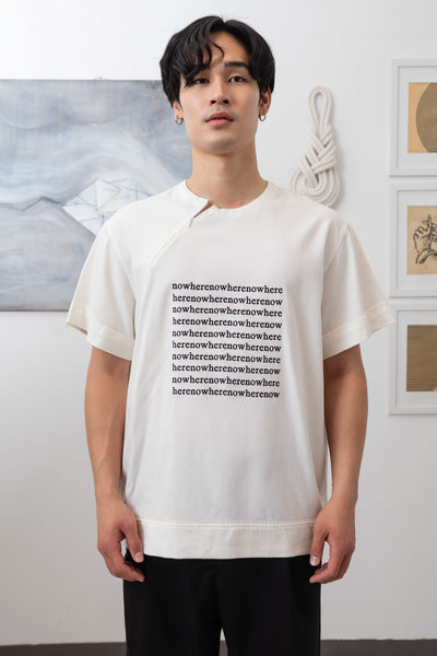 Close-up front of white menswear shirt showing invisible zipper neckline and logo embroidered graphic by nowhere studio