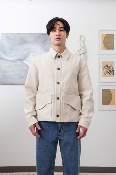 Ivory workwear jacket close-up front, Corozo buttons and sculptural curved pocket flap by nowhere studio