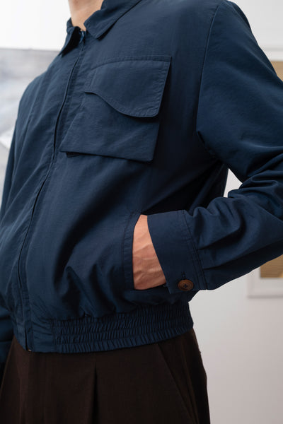 Navy Harrington jacket left side detail, elasticized waistband and welt pocket construction by nowhere studio