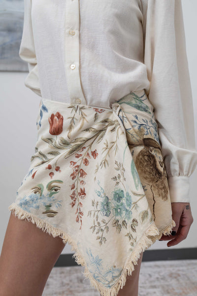 Close-up detail of hand-painted surrealist portraiture on vintage floral cotton with raw preserved edges, nowhere studio