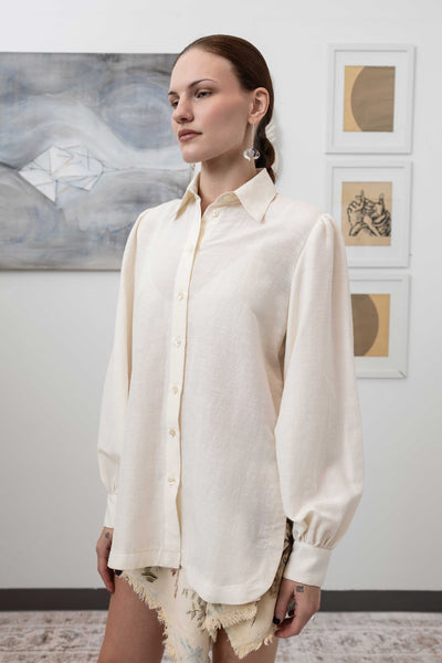 Close-up profile detail of sculptural blouse in ivory — architectural silhouette with exaggerated volume, nowhere studio
