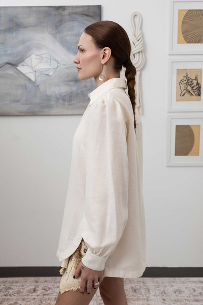 Close-up left side detail of sculptural blouse in ivory — architectural drape with structured woven finish, nowhere studio