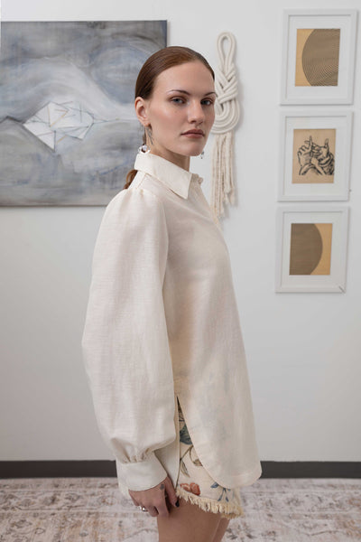 Close-up right side detail of sculptural blouse in ivory — construction detail with gathered volume and woven fabric, nowhere studio