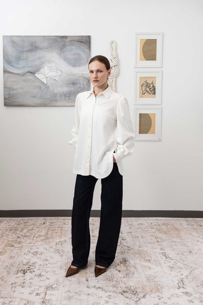 Sculptural blouse in white, left profile view — fluid sculptural structure with modernist form, nowhere studio