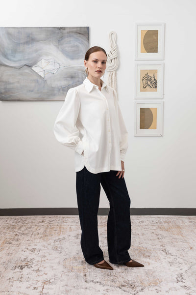 Sculptural blouse in white, right profile view — three-dimensional silhouette with exaggerated sleeve volume, nowhere studio