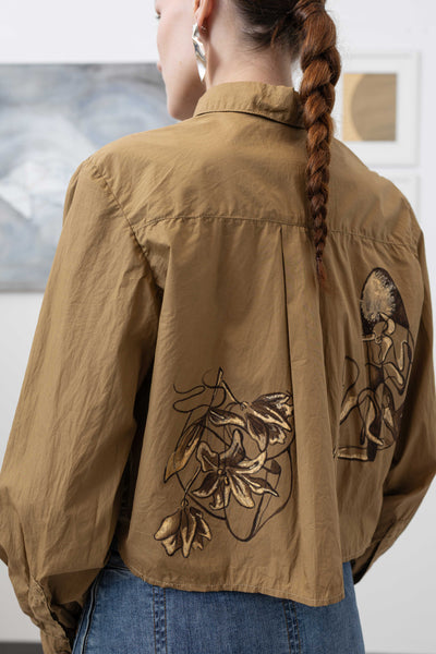 Close-up back alternate view of hand painted artisanal blouse in tan — painted detail and gathered sleeve volume, nowhere studio