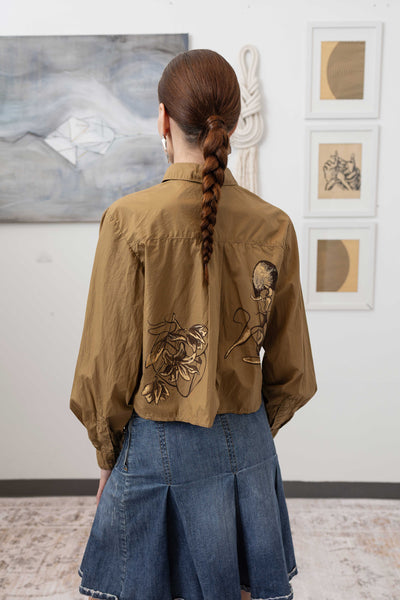 Close-up back detail of hand painted artisanal blouse in tan — artisanal painted finish with curved hem construction, nowhere studio