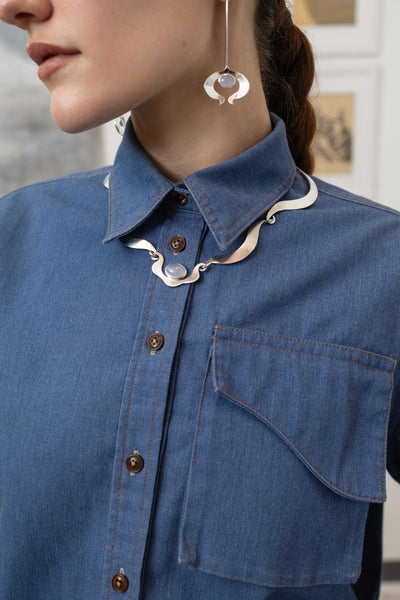 Front detail of three-dimensional cargo pocket with contrast topstitching on denim utilitarian shirt, nowhere studio
