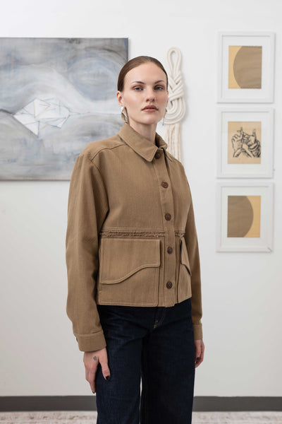 Close-up right front detail of workwear jacket in earth — Corozo button closure and curved flap pocket in brushed bull denim, nowhere studio