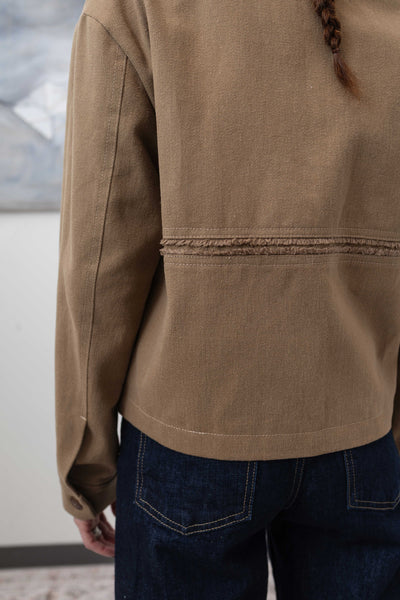 Back detail of workwear jacket in earth — selvedge fringe panel with nuanced textural finish, nowhere studio
