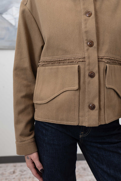 Pocket detail of workwear jacket in earth — sculptural curved flap with dual-entry construction, nowhere studio