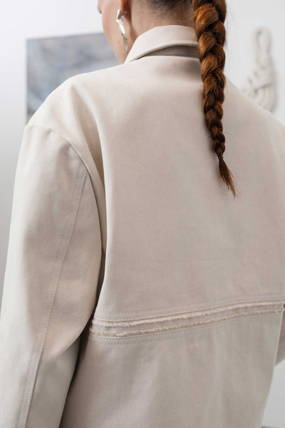 Back detail of workwear jacket in ivory — selvedge fringe centre panel with textural finish, nowhere studio