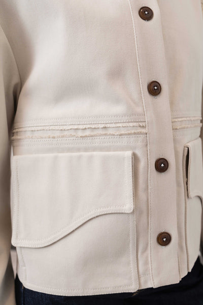 Pocket detail of workwear jacket in ivory — sculptural curved flap with dual-entry construction, nowhere studio