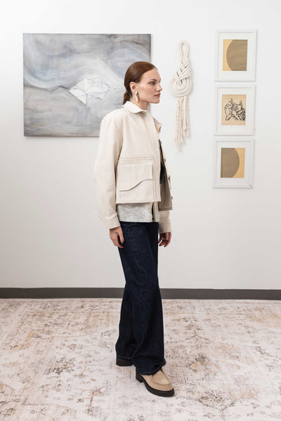 Workwear jacket in ivory, profile view — contemporary proportions with selvedge fringe centre panel and reinforced seams, nowhere studio