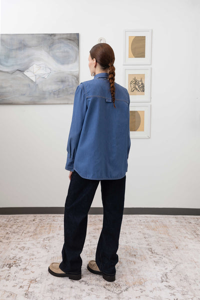 Full back left view of fisherman's vest in Denim mid-weight twill with double-needle topstitching and structured hem by nowhere studio