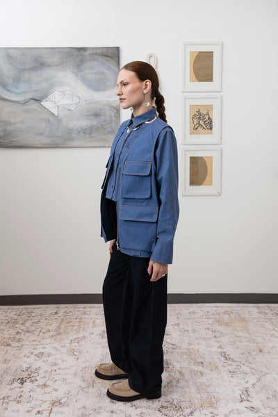 Full left profile view of fisherman's vest in Denim mid-weight twill with utilitarian pocket placement by nowhere studio
