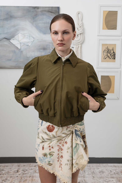 Close-up front view of sculptural blouson jacket in army — metal zip closure and welt pocket in sleek deadstock nylon, nowhere studio