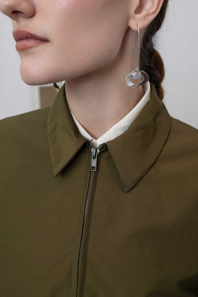Front detail of sculptural blouson jacket in army — metal zip and collar neckline on water-resistant nylon, nowhere studio