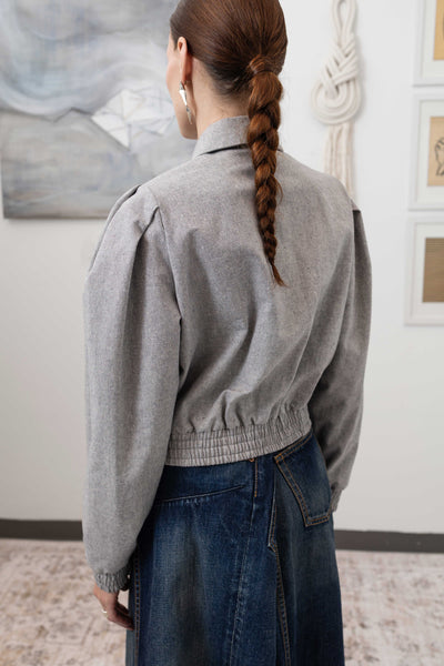 Close-up back left detail of sculptural blouson jacket in granite — elasticized hem and canvas construction, nowhere studio