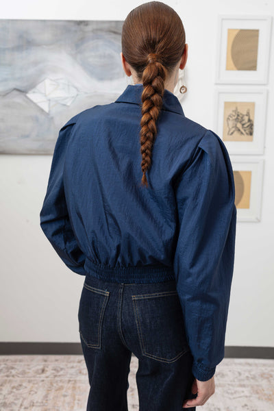 Close-up back alternate detail of sculptural blouson jacket in navy — elasticized hem and crinkled nylon construction, nowhere studio