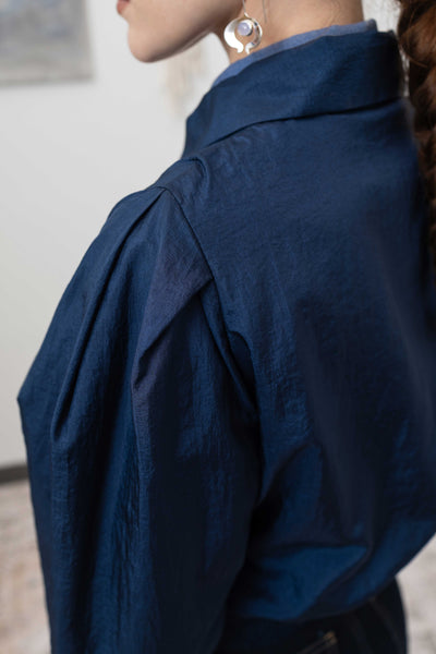 Back detail of sculptural blouson jacket in navy — sculptural form with pleated sleeve detail and lightweight nylon construction, nowhere studio
