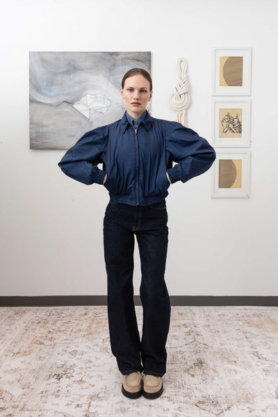 Sculptural blouson jacket in navy, full front view — rounded silhouette with metal zip and welt pockets in lightweight crinkled nylon, nowhere studio