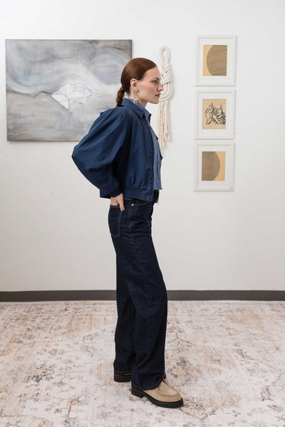 Sculptural blouson jacket in navy, right side view — softened structure with elasticized hem and crinkled nylon surface, nowhere studio